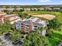 Aerial view of condo complex with golf course backdrop, showcasing the community's scenic location and amenities at 1100 Sunset View Cir # 204, Reunion, FL 34747