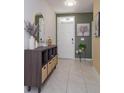 Inviting entryway with decorative console table, a mirror, stylish artwork, and neutral paint colors at 1287 Berry Ln, Davenport, FL 33837