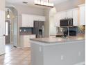 Well-equipped kitchen featuring white cabinets, stainless steel appliances, and tiled backsplash at 1322 Reagans Reserve Blvd, Apopka, FL 32712