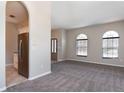 Cozy living room showcasing arched windows, neutral walls, and plush carpeting at 1322 Reagans Reserve Blvd, Apopka, FL 32712
