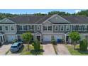 A row of townhomes featuring neutral tones, single-car garages, and brick-paved driveways at 150 Mitchell Creek Way, Oviedo, FL 32765