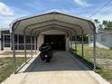View of the carport leading to the garage with a motorcycle parked inside at 1506 Carmen Ave, Daytona Beach, FL 32117