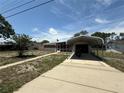 Quaint single-story home featuring a carport, driveway, and mature landscaping at 1506 Carmen Ave, Daytona Beach, FL 32117