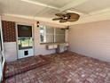 Charming brick-paved screened porch with ceiling fan and outdoor storage at 1506 Carmen Ave, Daytona Beach, FL 32117