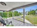 Charming front porch featuring tiled flooring, white columns, and a peaceful view at 1511 Chestnut Ave, Winter Park, FL 32789