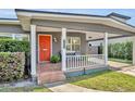 Welcoming front porch with a cozy seating area and an orange front door at 1511 Chestnut Ave, Winter Park, FL 32789
