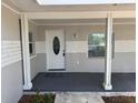Covered front porch with classic columns, decorative door, and ambient lighting provides inviting entry at 1526 Cordova Ave, Holly Hill, FL 32117