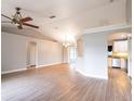 Open-concept living area with wood floors and neutral paint, leading into the kitchen at 1639 Yellow Brick Rd, Astor, FL 32102