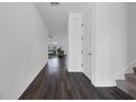 Hallway with dark wood flooring leading to the living room and stairs to the right at 2210 Derwent Dr, Davenport, FL 33896