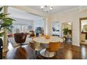 Bright dining room with a round marble table, seating for six, hardwood floors, and neutral walls at 2305 Edgewater Dr # 1613, Orlando, FL 32804