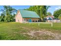 A charming home featuring a metal roof, a blue front door, and a spacious green lawn at 287 Hilltop Dr, Longwood, FL 32750