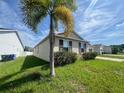 Home exterior with lush green lawn and tidy landscaping beneath a sunny sky at 2983 Boating Blvd, Kissimmee, FL 34746