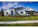 Well-manicured lawn and landscaping accent this single-story home with stone accents and a sales center entrance at 3126 Wolf Lake Ave, Apopka, FL 32712