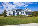 Charming single-story home boasts a manicured front lawn, stone accents, arched entryway, and a sales center at 3126 Wolf Lake Ave, Apopka, FL 32712