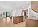 Bright open kitchen featuring stainless steel appliances, large island, and dining area with backyard view at 3280 Canna Lily Pl, Clermont, FL 34711