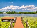 Scenic view of a dock leading to a lake with lush greenery and a blue sky at 3443 S Mellonville Ave, Sanford, FL 32773