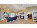 Spacious open-concept living room featuring wood floors, vaulted ceilings, and a seamless transition to the dining area at 6198 Linneal Beach Dr, Apopka, FL 32703