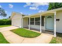 Home featuring a charming covered front porch, well-kept lawn, and attached garage at 620 Marshall St, Altamonte Springs, FL 32701