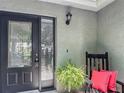 Inviting front porch featuring a stylish glass front door, chair, and decorative plants at 620 Wood Dr, Kissimmee, FL 34759