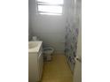 Simple bathroom featuring a vanity, toilet, and shower with a patterned curtain at 6251 Bolling Dr, Orlando, FL 32808