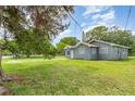 Side view of a charming home with light blue exterior, lush lawn, and mature trees at 660 6Th St, Daytona Beach, FL 32117