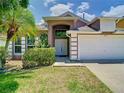 Stunning home showcasing double doors, well-kept bushes, and a two-car garage with ample parking at 6843 Cherry Grove Cir, Orlando, FL 32809