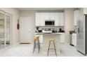 Modern kitchen featuring white cabinets, stainless steel appliances, and island with seating at 7163 Sienna Oak Aly, Orlando, FL 32829