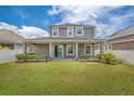 Well-maintained backyard featuring a covered patio, lush lawn, and privacy fence at 8230 Corkfield Ave, Orlando, FL 32832