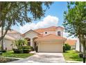 Well-maintained home features a tile roof, two car garage, and brick driveway with landscaping at 8418 Via Bella Notte, Orlando, FL 32836