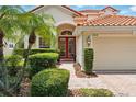 Inviting home entrance with manicured bushes framing a brick walkway leading to red double doors at 8418 Via Bella Notte, Orlando, FL 32836