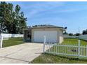 Single-story home with an attached two-car garage, visible driveway, and manicured lawn at 909 San Paulo Way, Kissimmee, FL 34758