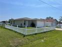 A single-story home surrounded by a white picket fence and lush green grass at 909 San Paulo Way, Kissimmee, FL 34758