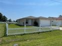 Single-story home with green grass and a white picket fence, offering classic curb appeal at 909 San Paulo Way, Kissimmee, FL 34758