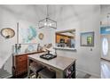 Cozy dining area featuring a modern light fixture, stylish decor, and a convenient pass-through to the kitchen at 116 Candlewick Ct, Sanford, FL 32771