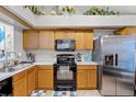 Functional kitchen with stainless steel refrigerator, oak cabinetry, and white countertops at 116 Candlewick Ct, Sanford, FL 32771