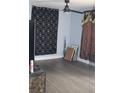 Living room with grey flooring, black and gold curtains and a ceiling fan at 1212 Leon Ln, Daytona Beach, FL 32117