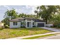 Beautiful single-story home featuring a gray exterior, lush landscaping, and an attached two-car garage at 1331 19Th St, Orlando, FL 32805