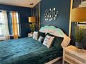 Inviting main bedroom with calming blue walls, a unique headboard, and soft lighting at 14501 Damai Ln, Orlando, FL 32821