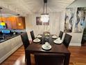 Elegant dining room featuring dark wood table and chairs, chandelier, and contemporary art at 14513 Damai Ln, Orlando, FL 32821