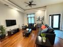 Open living room features hardwood floors, tray ceiling, and comfortable leather seating arrangements at 14513 Damai Ln, Orlando, FL 32821