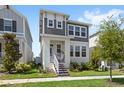 Beautiful two-story home featuring a cozy front porch, well-maintained lawn, and modern design at 15444 Lebeau Loop, Winter Garden, FL 34787