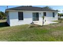 Back exterior view of home showing a grassy yard and sliding glass door access to the house at 1750 Mitten Ter, Deltona, FL 32738