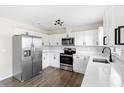 Well-lit kitchen featuring stainless steel appliances, white cabinets, and sleek countertops at 1750 Mitten Ter, Deltona, FL 32738