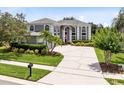 A sprawling two-story home features a prominent entryway, manicured lawn, and oversized driveway at 2214 Westbourne Dr, Oviedo, FL 32765