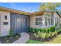 Inviting front entrance with a modern dark-colored door, beautiful landscaping, and brick walkway at 2520 Chanute Trl, Maitland, FL 32751