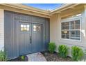 Stylish front door with sidelight windows, complemented by manicured shrubs and a brick path at 2520 Chanute Trl, Maitland, FL 32751