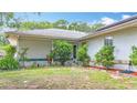 This exterior features a well manicured lawn, lush landscaping, and a chair on the porch at 2771 Ne 66Th St, Ocala, FL 34479