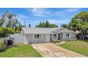 A well-maintained home featuring a side entry garage, lush lawn, and manicured landscaping at 2835 Bongart Rd, Winter Park, FL 32792