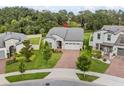 Aerial shot of a single-Gathering home with a well-kept lawn, brick driveway, and a two-car garage in a lush neighborhood at 2914 Scarlett Dr, St Cloud, FL 34772