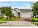 Inviting single-Gathering home with a brick driveway, a two-car garage, and neatly trimmed shrubs at 2914 Scarlett Dr, St Cloud, FL 34772